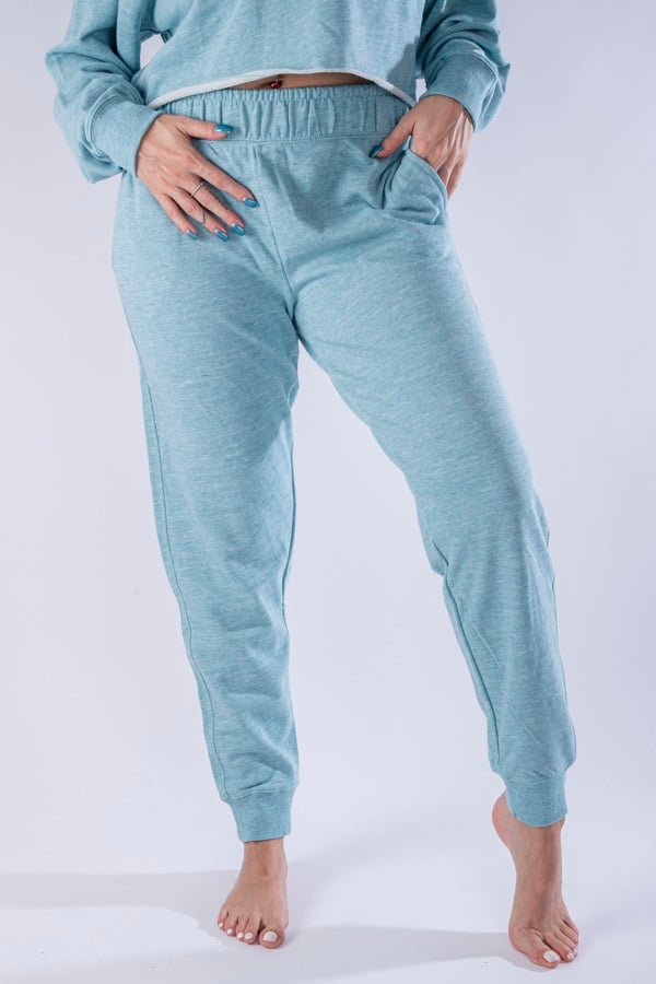 Femme vue de face portant un jogging en french terry de couleur menthe avec des poches.