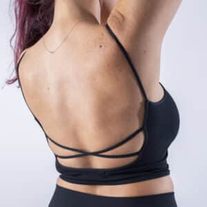 Femme portant un top dos nus avec design croisé dans le dos.
