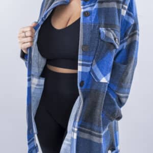 Femme vue de face portant une veste en plaid de couleur bleu ciel avec des poches avants et latérales. Fermeture par boutons à l'avant.