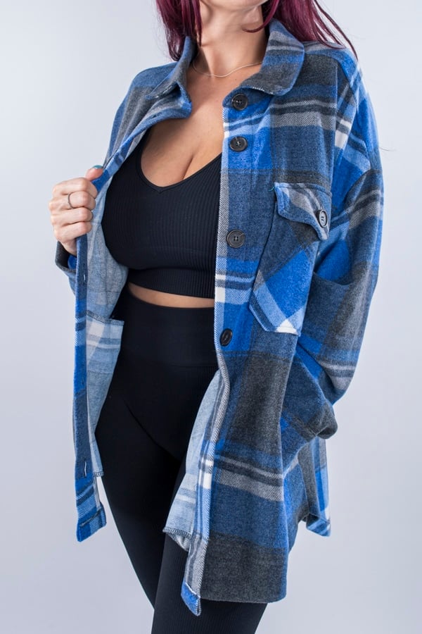 Femme vue de face portant une veste en plaid de couleur bleu ciel avec des poches avants et latérales. Fermeture par boutons à l'avant.